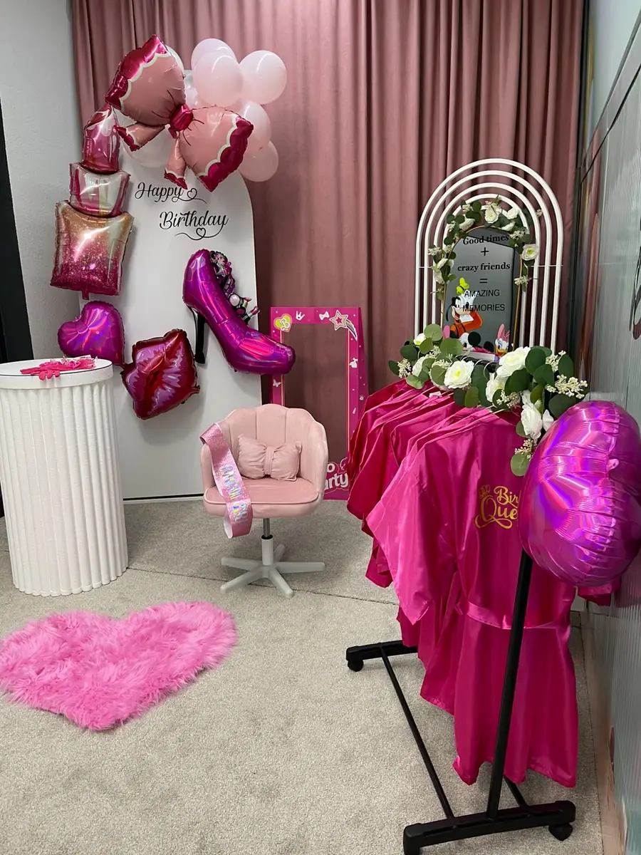 The styling corner with a pink chair, balloons and pink satin robes